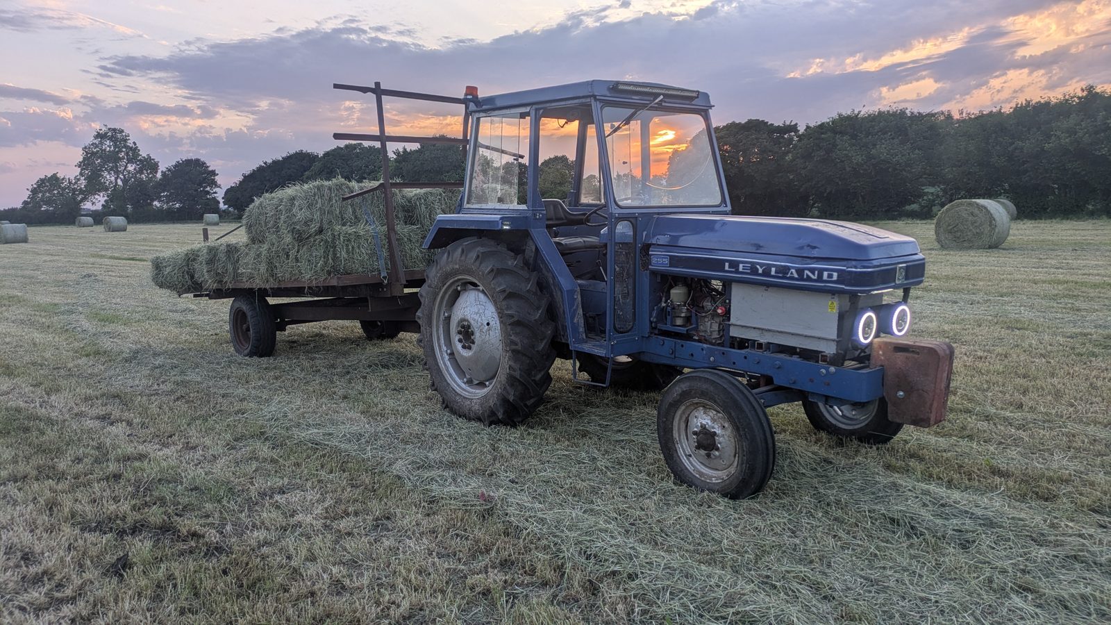 Leyland 255 hauling hay bales at sunset